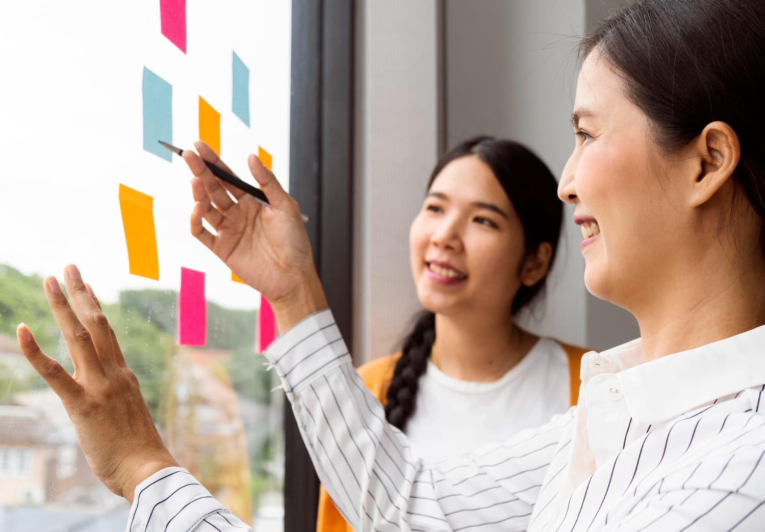 Image of two ladies discussing about work using Post-Its